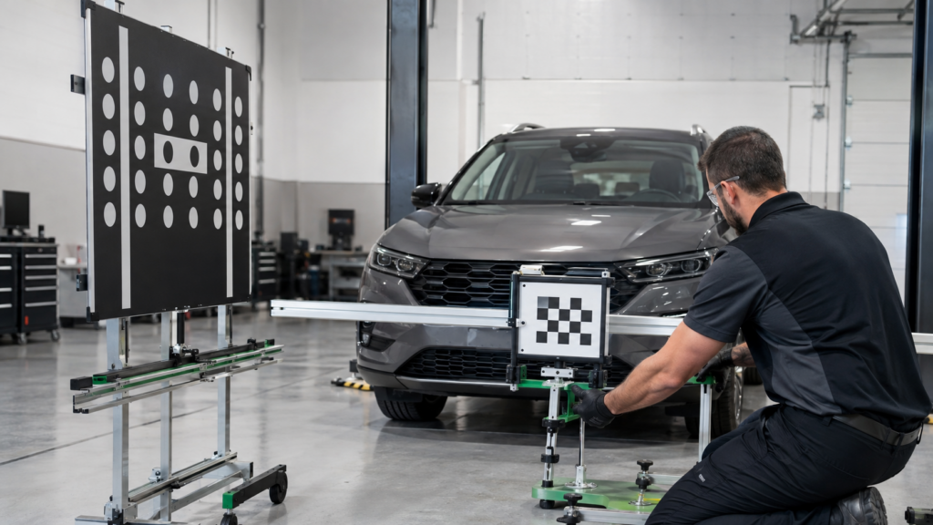 Automotive technician calibrating cameras and sensors used by driver assistance systems